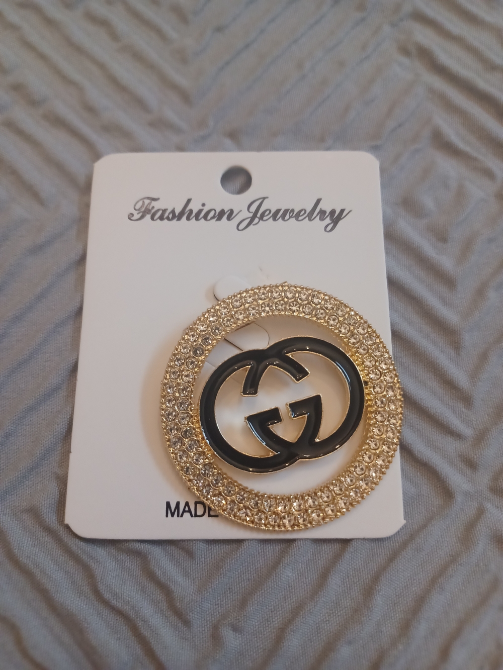 Fashion Jewelry Gold-Tone Crystal Circle Brooch with Black Interlocking Logo